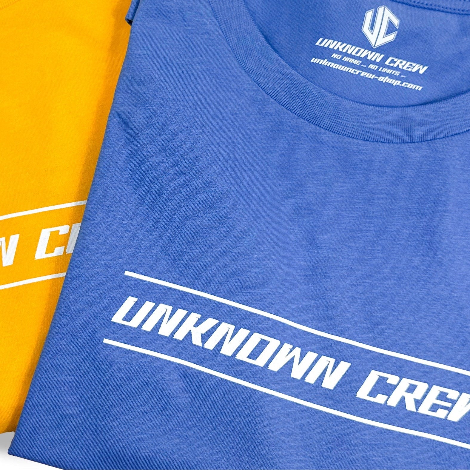 Cols de t-shirts bleu et orange imprimés Unknown Crew en blanc, étiquette intérieure UC visible.