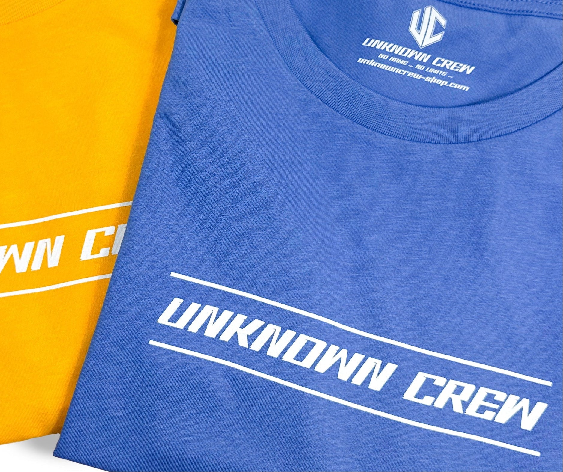 Cols de t-shirts bleu et orange imprimés Unknown Crew en blanc, étiquette intérieure UC visible.